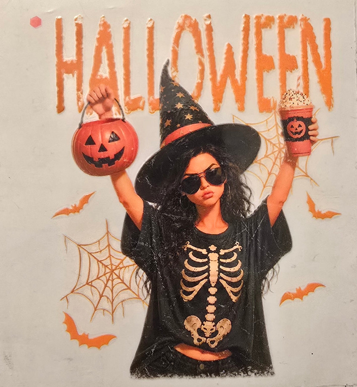 Halloween witch in a skeleton shirt holding a pumpkin bucket